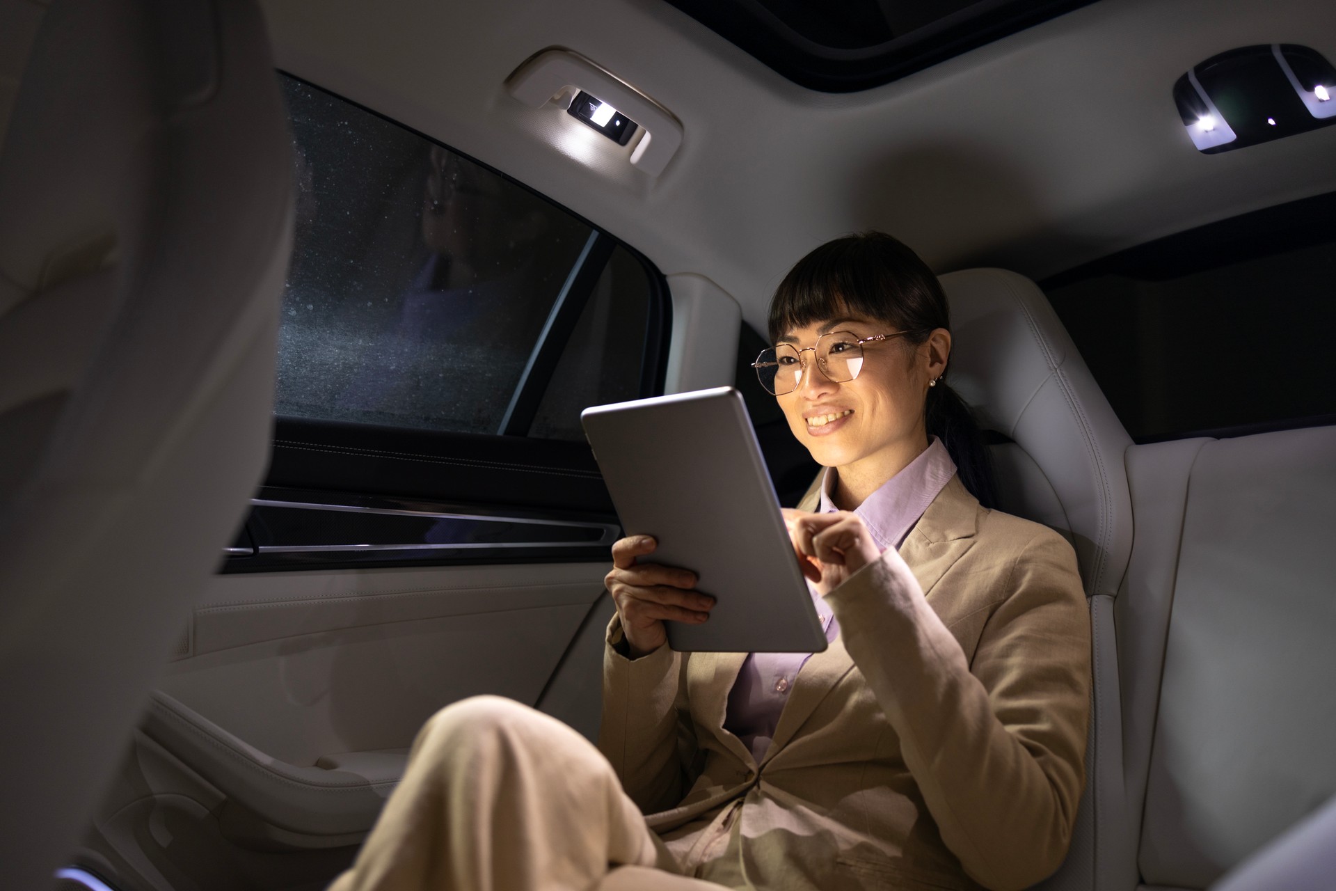 Woman in business suit traveling by luxury car.